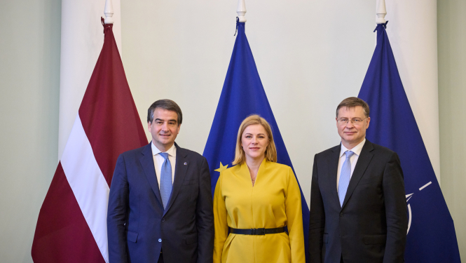 Fotogrāfijā pie Latvijas, Eiropas Savienības, NATO karogiem no labās Eiropas Komisijas priekšsēdētājas izpildvietnieks kohēzijas un reformu jautājumos Rafaēle Fito, Ministru prezidente Evika Siliņa, Eiropas Komisijas priekšsēdētājas izpildvietnieks jautājumos par ekonomiku Valdis Dombrovskis